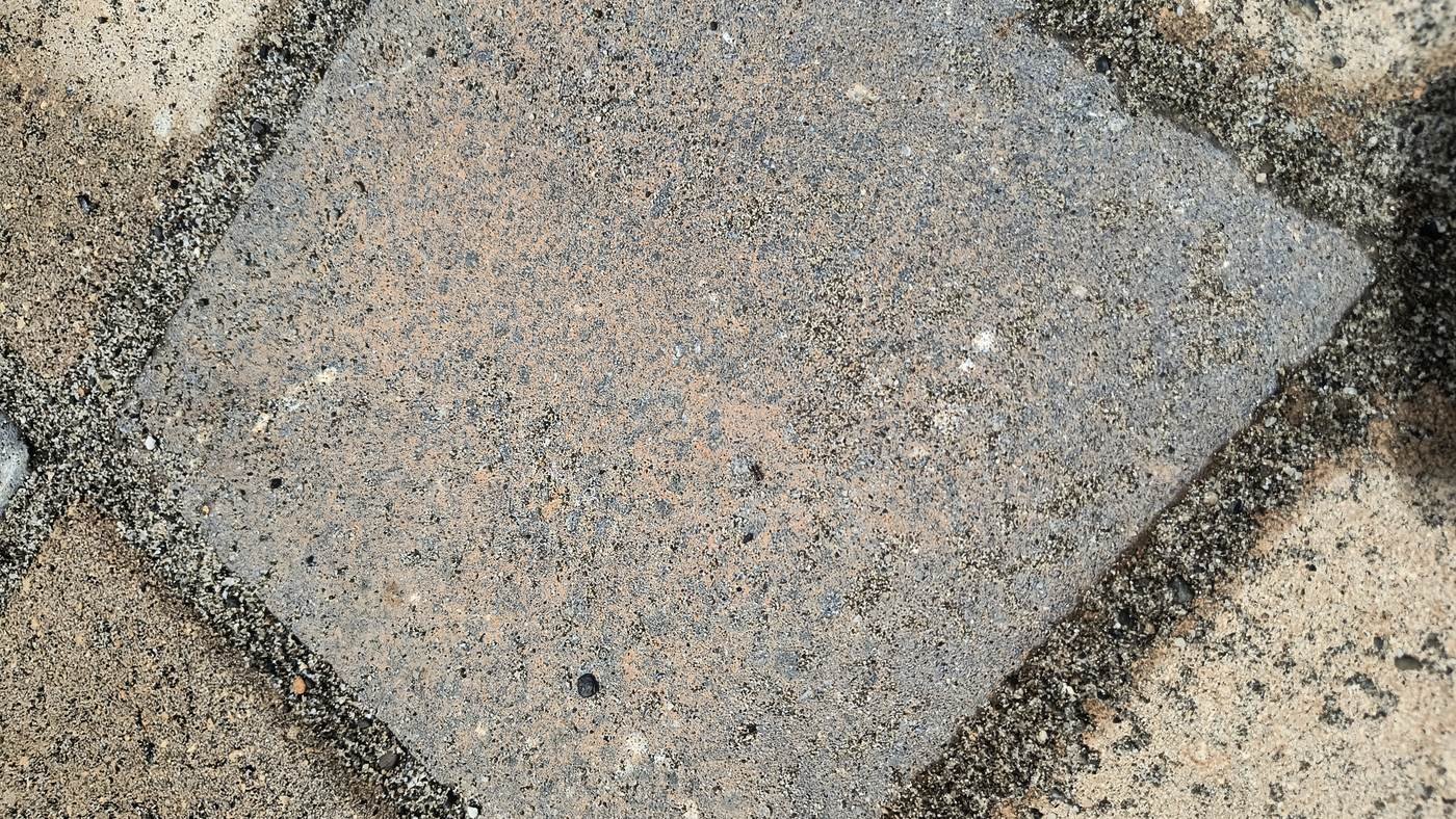 Detalle de una pieza de concreto de tono claro con un velo blanquecino leve sobre su cara vista, apenas distinguible del color propio de la pieza